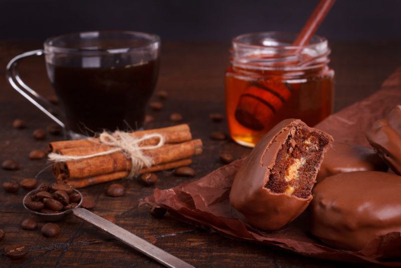 A mug of coffee, with honey, cinnamon and chocolate biccies