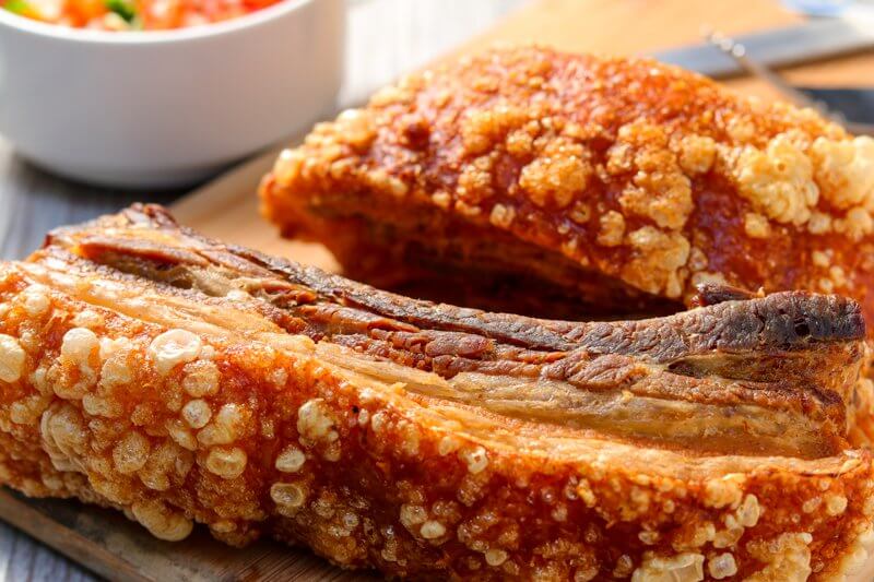 Pieces of Colombian style pork belly on a wooden board