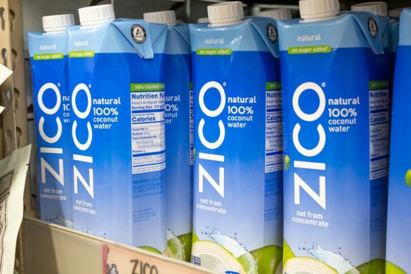 Cardboard packs of coconut water on a grocery store shelf