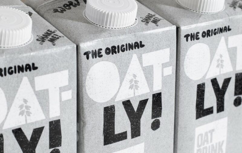 Three gray boxes of Oat-ly oat milk on a shelf