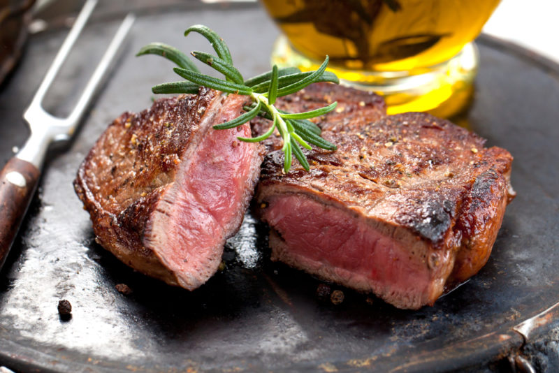 A large cooked steak that has been cut in half and is rare in the middle