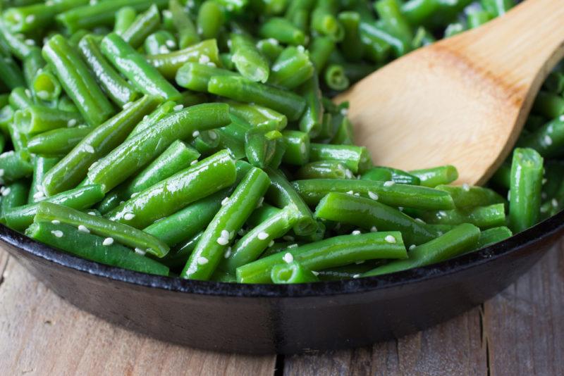 A shallow black bowl of cooked beans