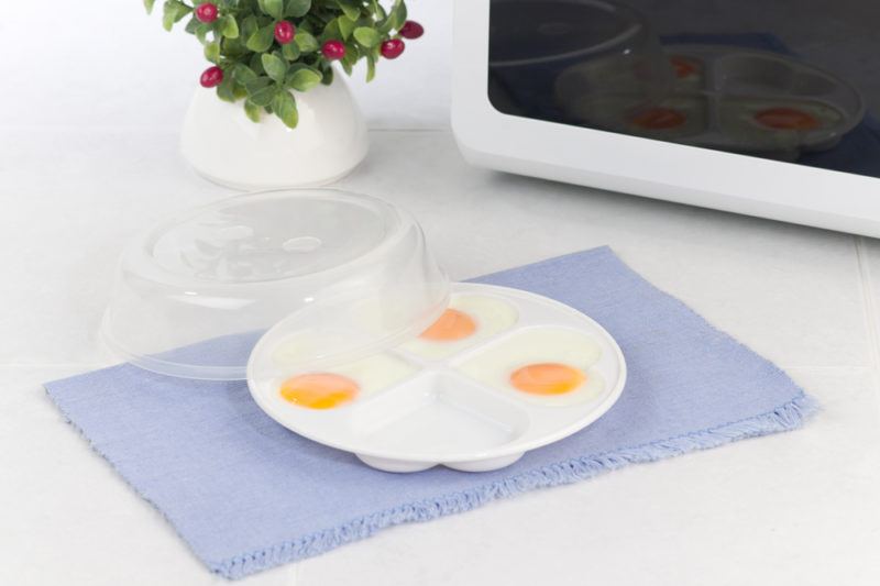 Eggs next to a microwave in a microwave tray