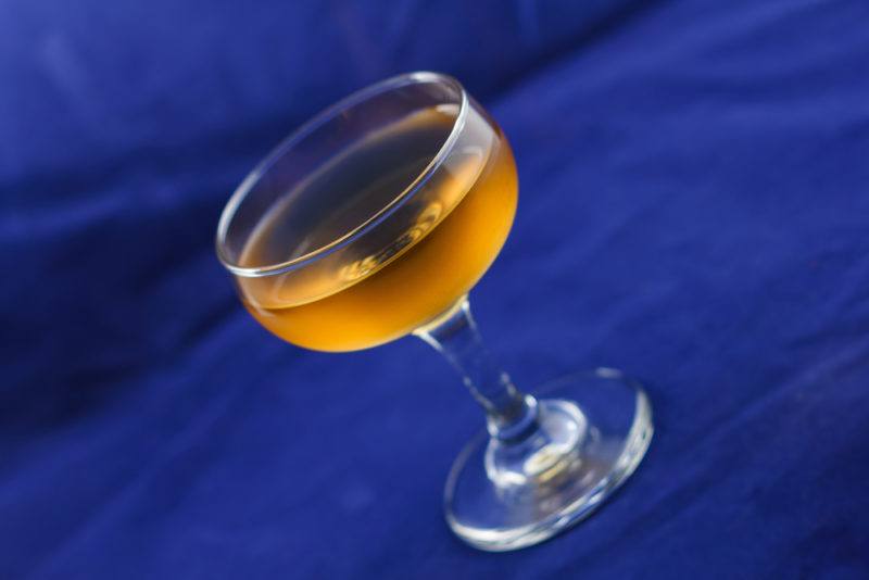 A Corpse Reviver No 1 cocktail against a blue background