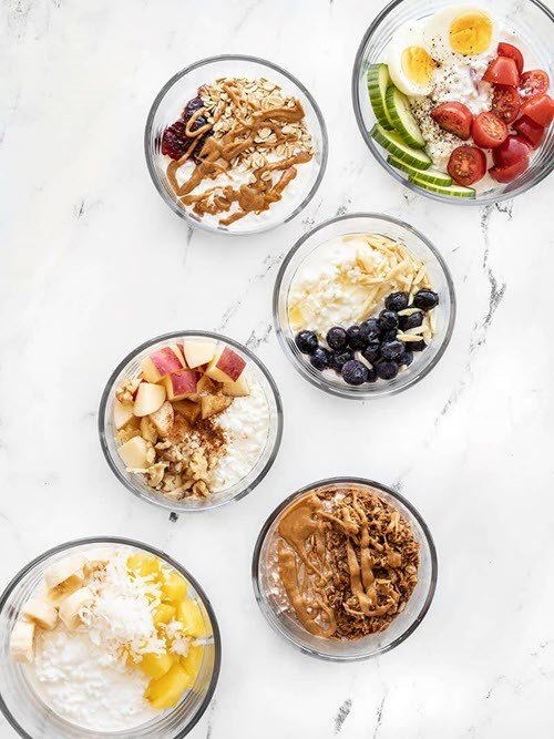 Six small bowls of cottage cheese with various toppings