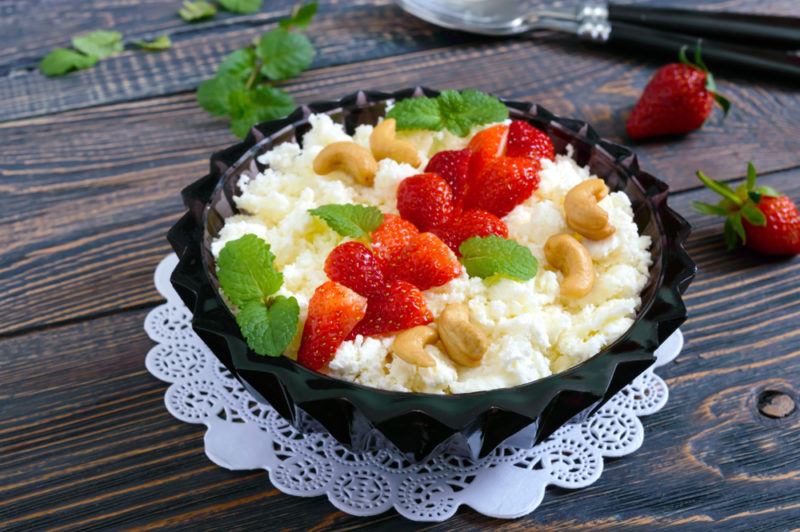 A black bowl containing cottage cheese and fruit