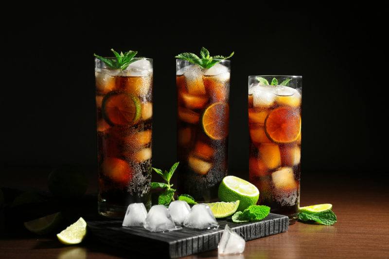 Three tall glasses of rum and coke with lime - a cuba libre