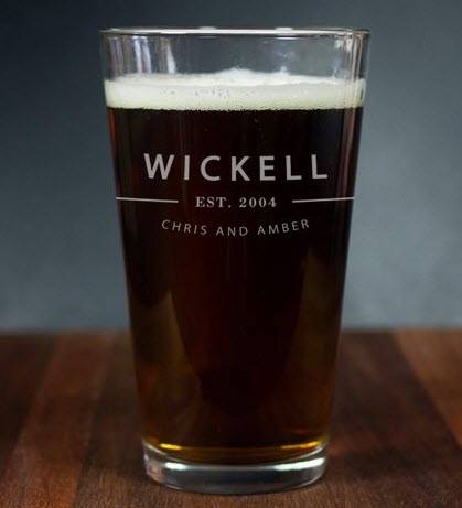 Single beer glass filled with beer with custom engraving. 