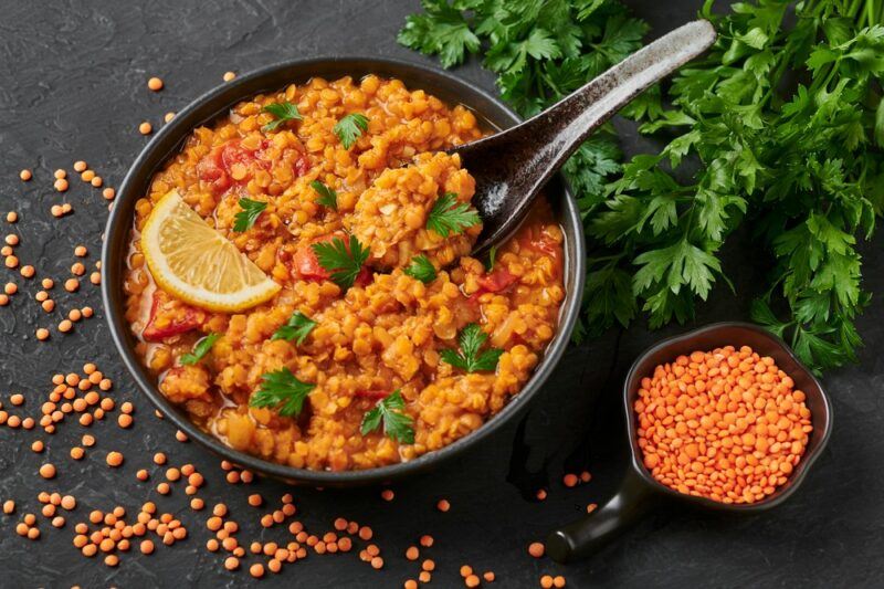 A black bowl with a daal made using red lentils and a small bowl of red lentils