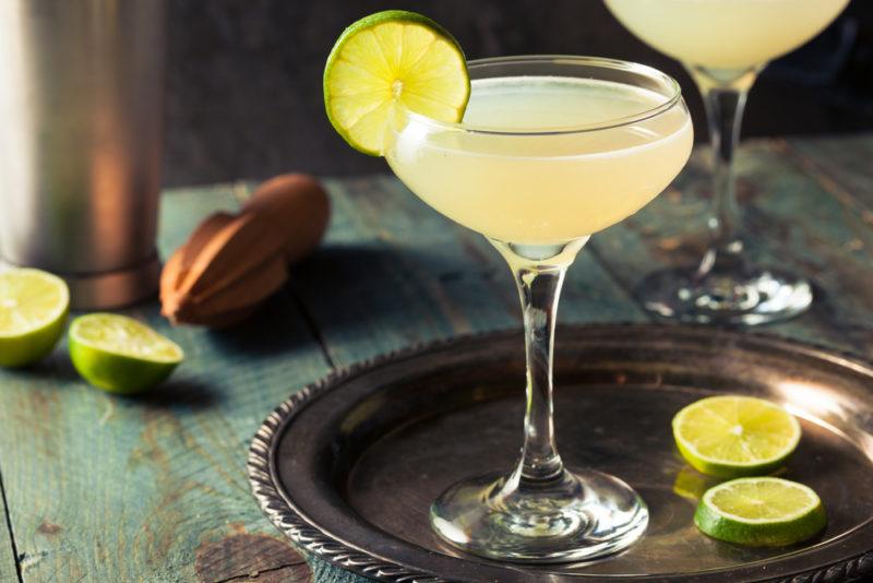 Two daiquris on a table with limes scattered around