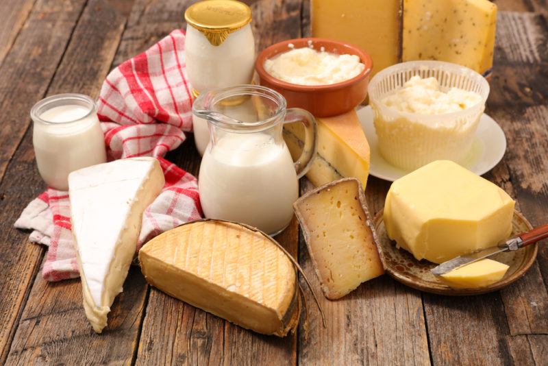 Various dairy products on a table, including cheeses and milk