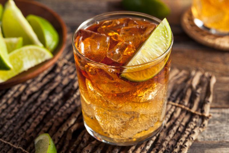 A dark and stormy cocktail with ice and lime