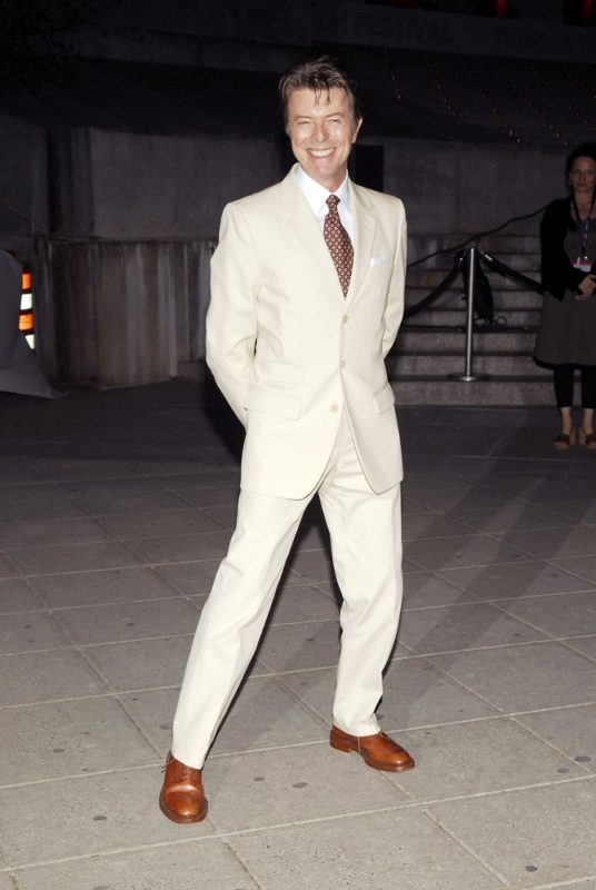 David Bowie posing for a photo in a white suit