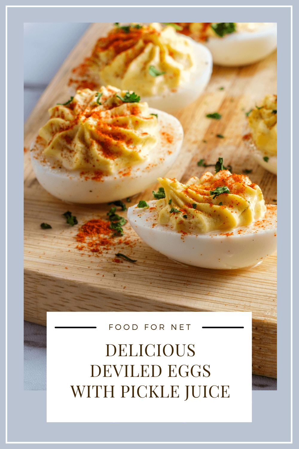 A wooden board with some deviled eggs with pickle juice that have been topped with paprika and chives