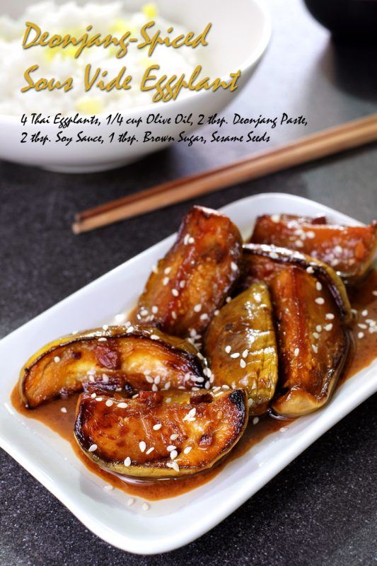 A white plate containing pieces of deonjang-spiced eggplant that has been cooked using sous vide and topped in sesame seeds. 