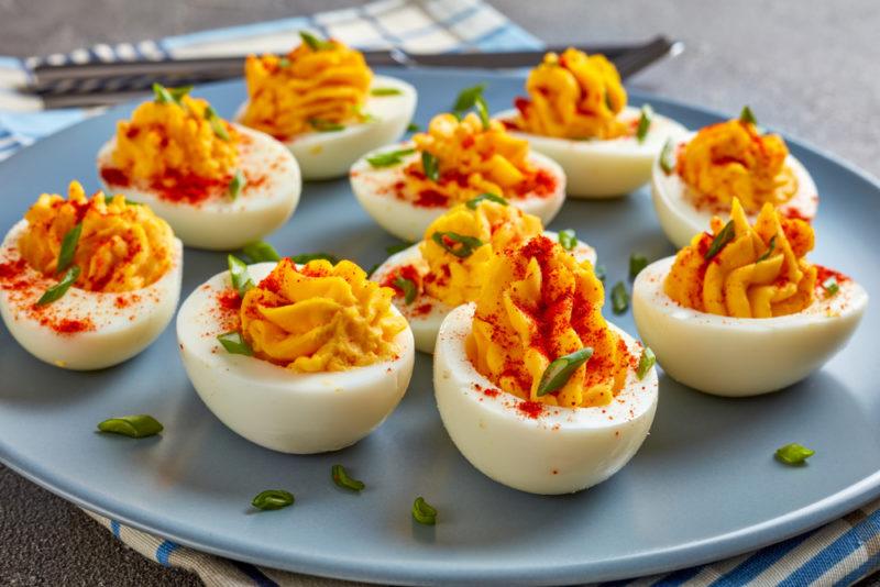 A blue plate with deviled eggs and paprika