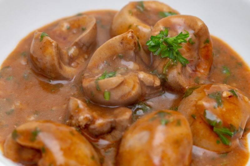 A white bowl of deviled kidneys in sauce