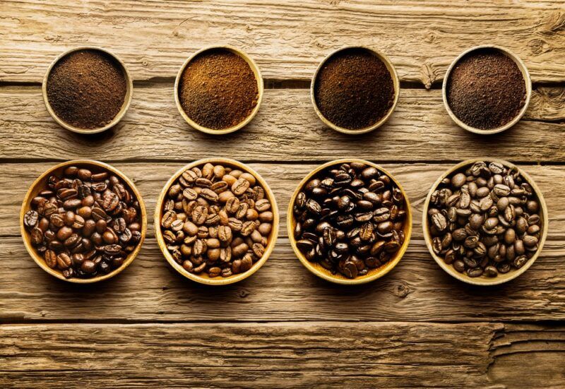 Four different types of coffee roasts, in bean and ground form