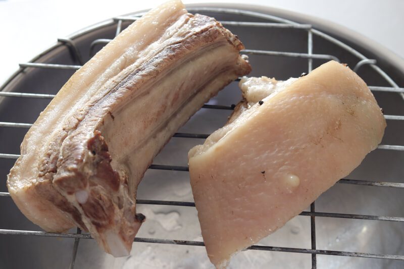 Tender pieces of pork belly on a draining tray