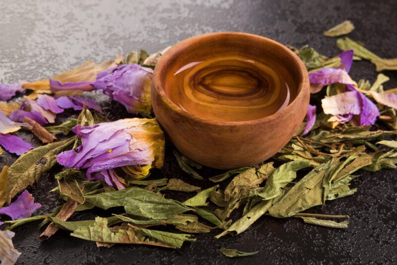 Dried leaves and flowers from a Mexican dream plant, surrounding a small wooden bowl