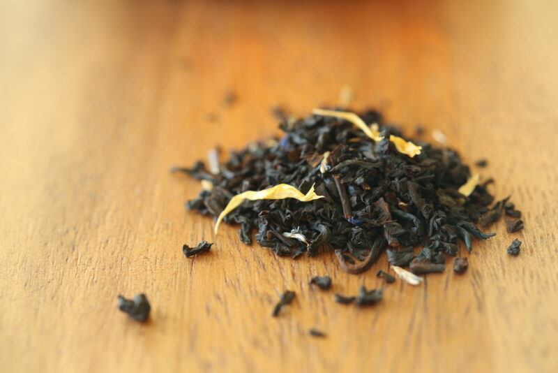 on a wooden surface is a small pile of loose Earl Grey tea