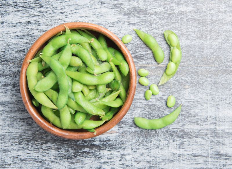 A brown bowl containing edamame