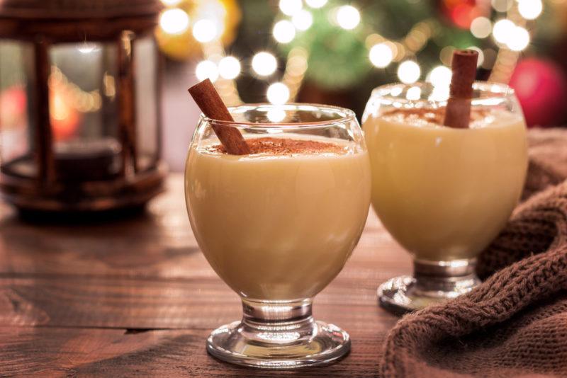 Two glasses of eggnog with a cinnamon stick