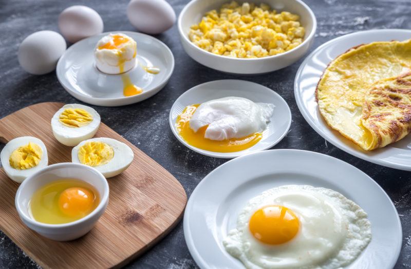 Eggs that have been cooked in various ways and served on white plates