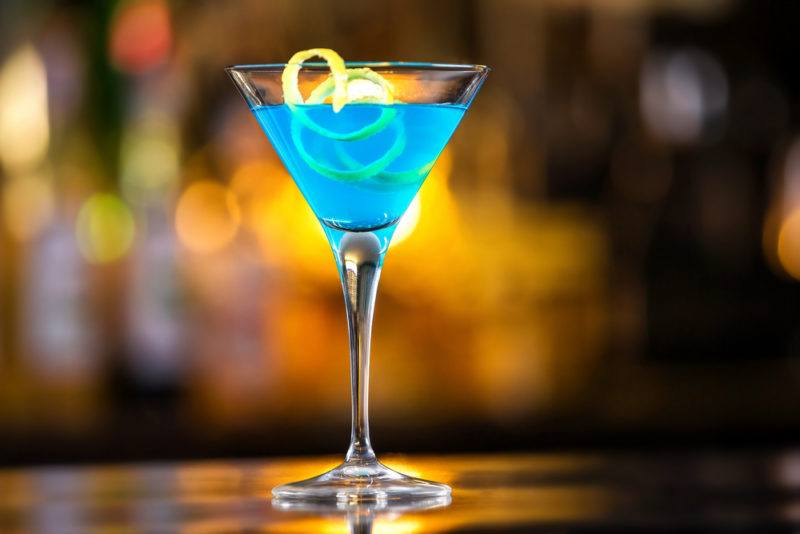 A bright blue Envy cocktail in a martini glass