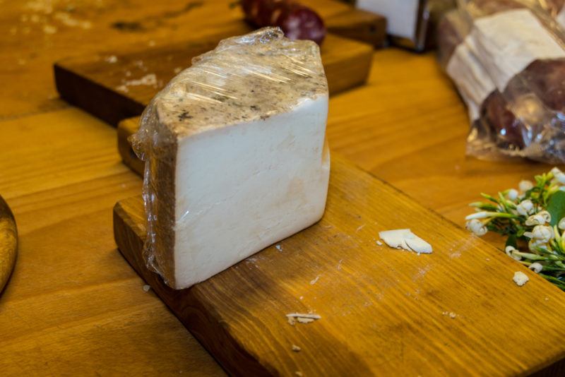 A piece of fiore sardo cheese on a wooden board