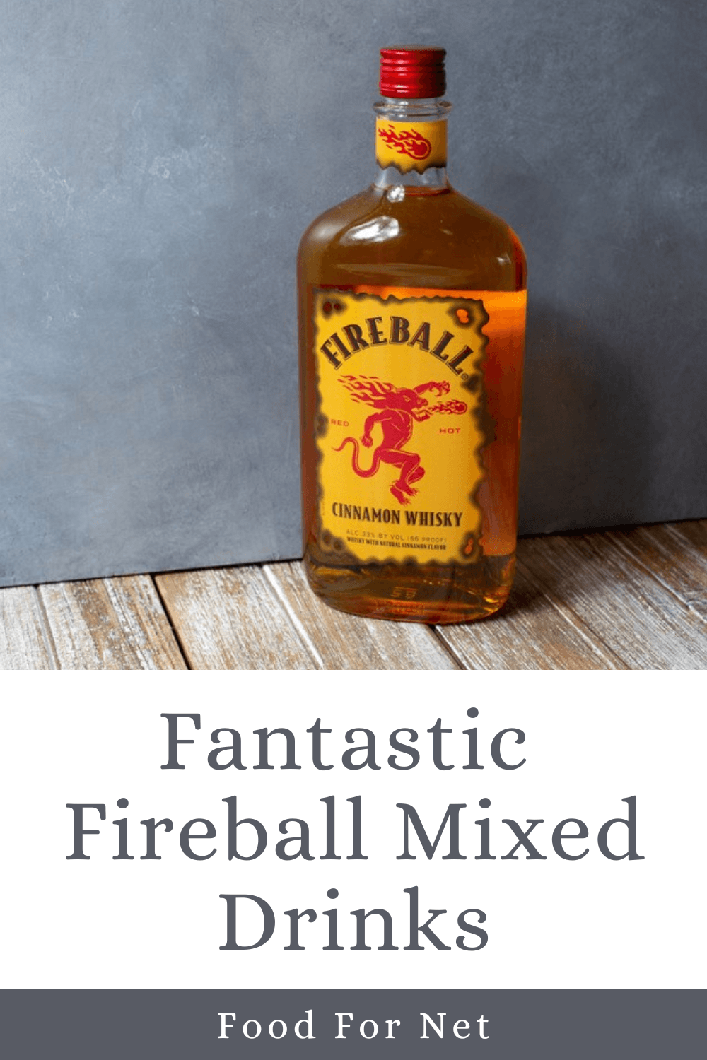 A bottle of Fireball whiskey on a wooden table against a gray background, highlighting the potential of Fireball mixed drinks