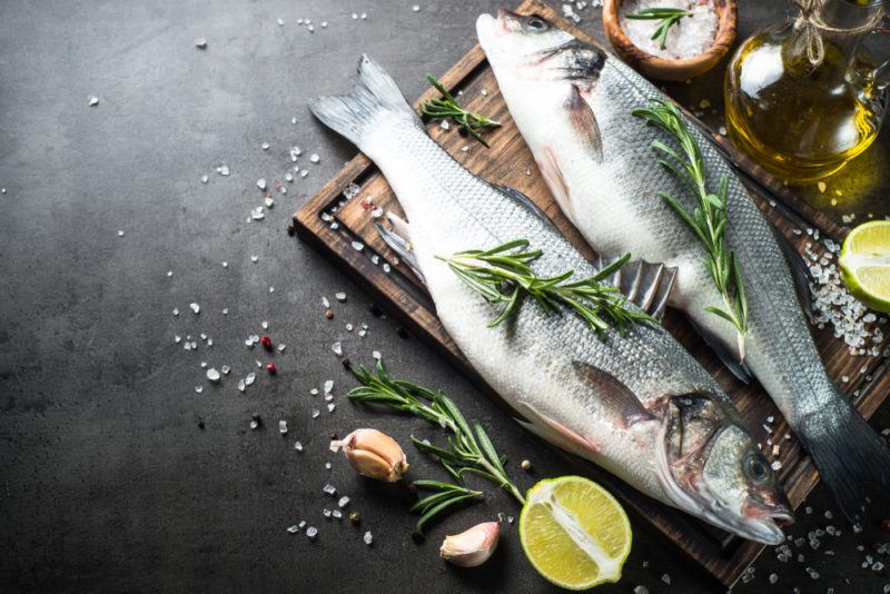 Two fresh fish on a wooden tray