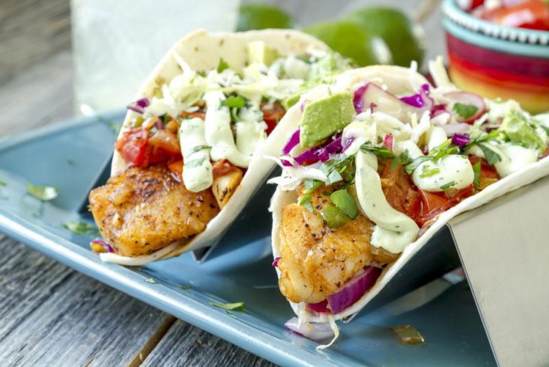 Two fried chicken tacos on a blue plate