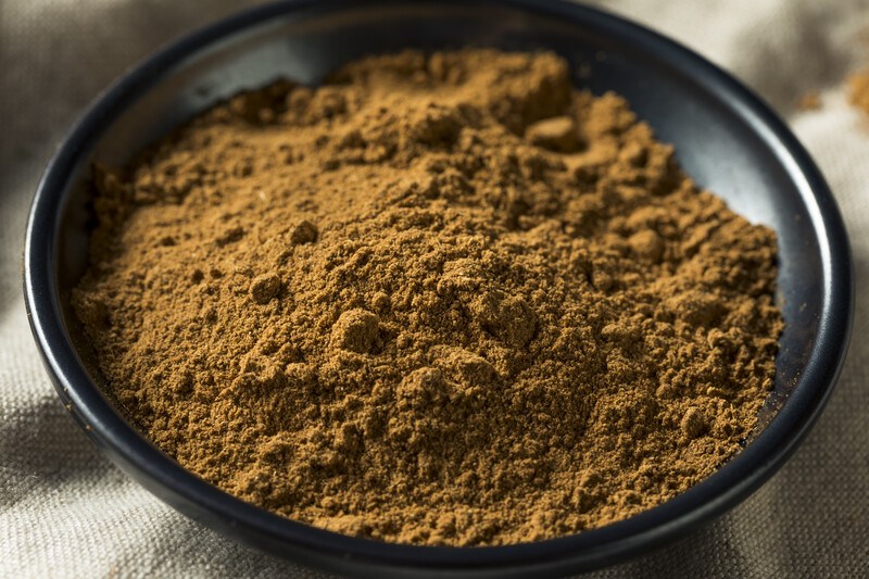 closeup image of five-spice powder in a black ceramic bowl