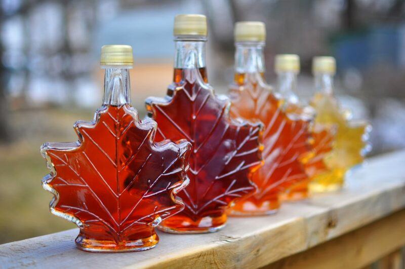 Five bottles of different colored maple syrup