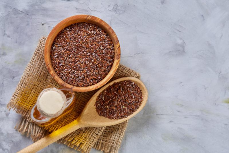 A brown bowl and spoon with flaxseeds