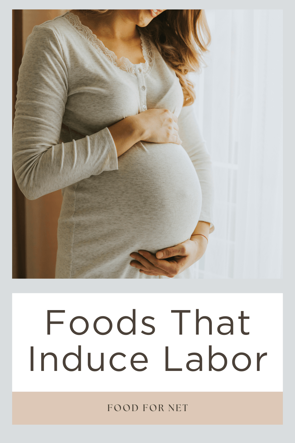 Foods That Induce Labor. A pregnant woman next to a window, looking down at her stomach, wondering about foods that induce labor