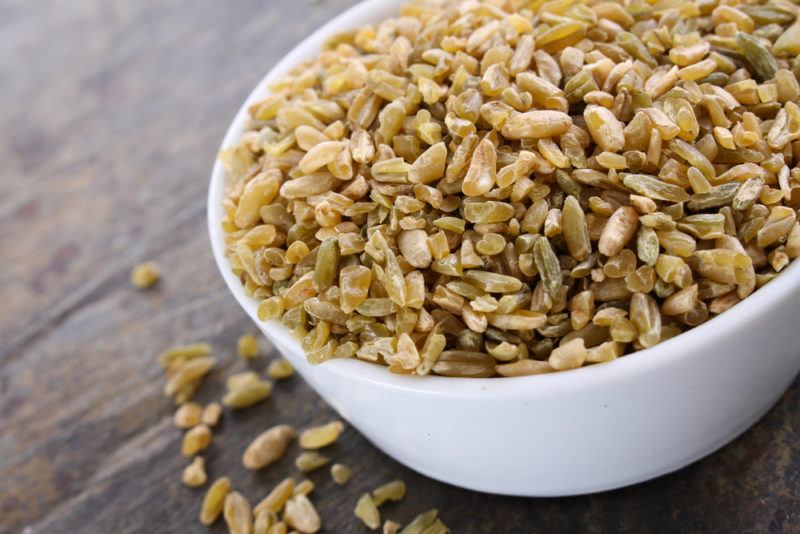 A white bowl of freekeh on a table