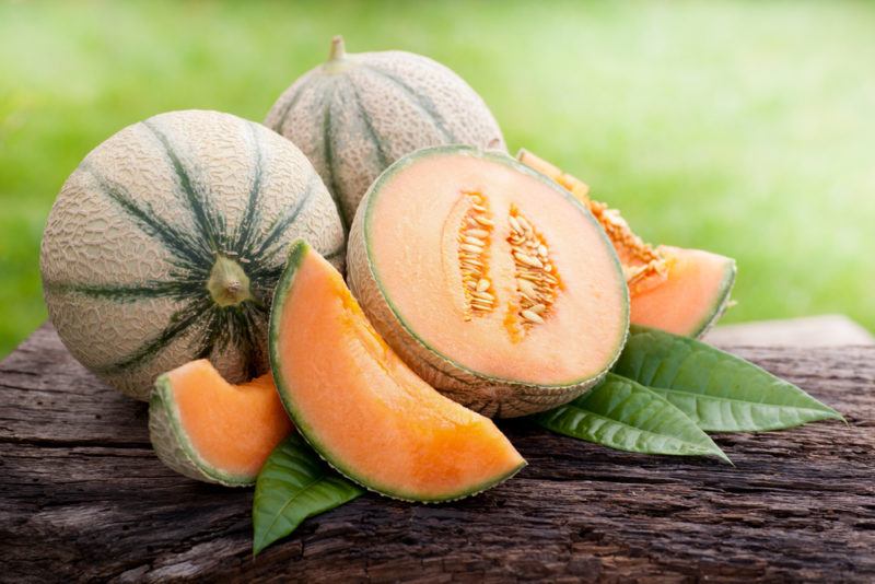 Two whole cantaloupes and another that has been sliced up