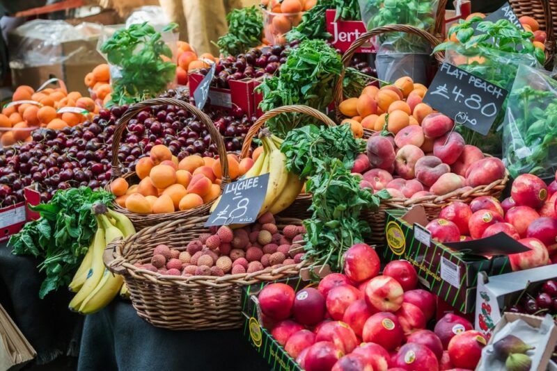 A large number of fresh fruits and vegetables arrayed on a table