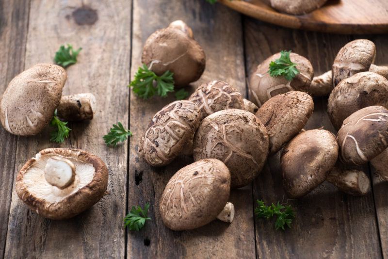 A wooden table with a selection of cooked mushrooms