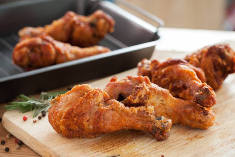 Fried chicken for a BBQ | Food For Net Fried chicken drumsticks on a wooden board with more in a dish