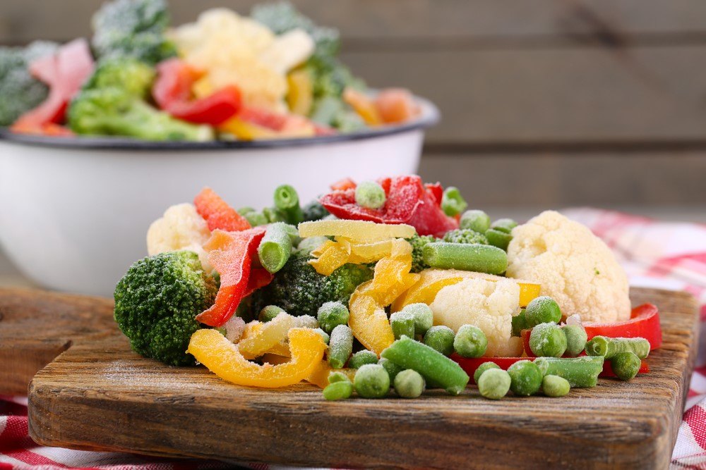 Frozen vegetables on a plank and in a bowl