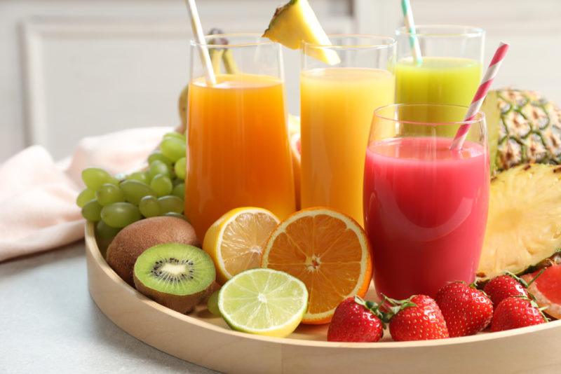 Glasses of fruit juice and fruit on a tray