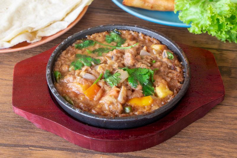 A bowl of ful medames on a red plate or napkin