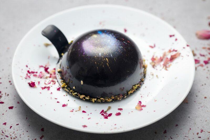 A white plate with a galaxy style chocolate mousse cake