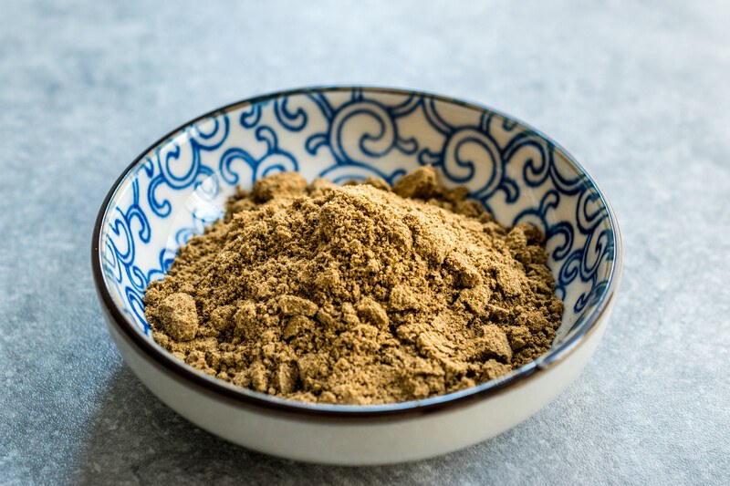 garam masala in a ceramic bowl with blue design, resting on a marble surface