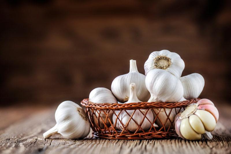 A basket of garlic bulbs on a table