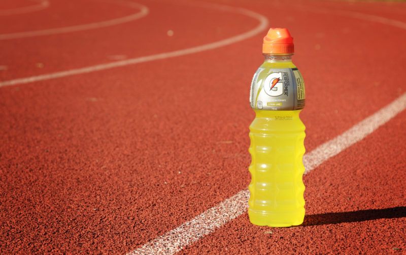 A bottle of yellow Gatorade on a running track