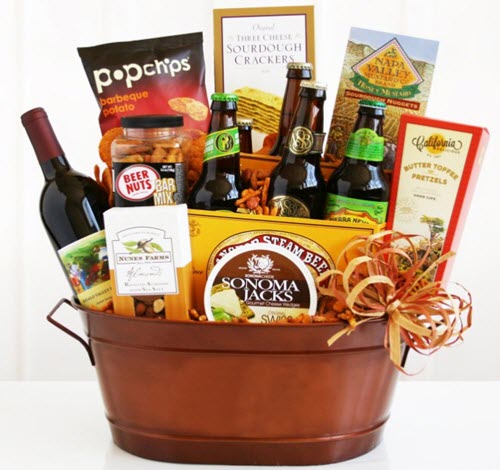 A copper tub containing a large selection of snacks, beer and a bottle of wine. 